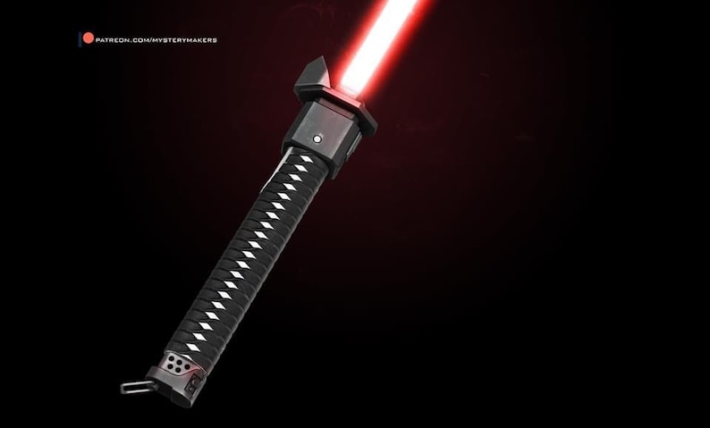 Puede incluir: Un sable de luz negro con una hoja roja y un mango estilo katana. El mango tiene un agarre con un patr&oacute;n blanco y negro.