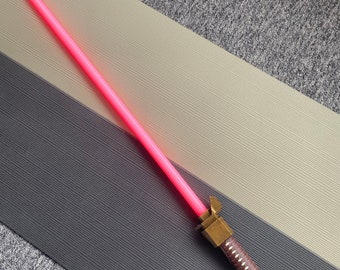 Empuñadura de sable de luz Ronin con hoja y componentes electrónicos.