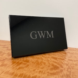 May include: A black rectangular box with the initials "GWM" engraved in silver lettering.