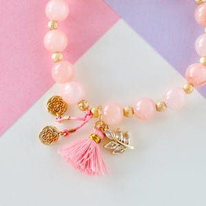 Armband van natuursteen in pastel abrikooskleur met kwastjes en lotushangers – kralen van 8 mm, elegant, elastisch, zomersieraad