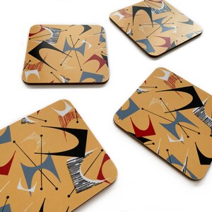 May include: Four square coasters with a mid-century modern design. The coasters feature a geometric pattern in shades of red, blue, black, and white on a yellow background.