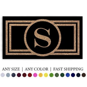 May include: A rectangular black doormat featuring a central circle containing the letter S, framed by a double rectangular border in a textured copper color. The text Doormat Decor appears above, with Any Size | Any Color | Fast Shipping below.