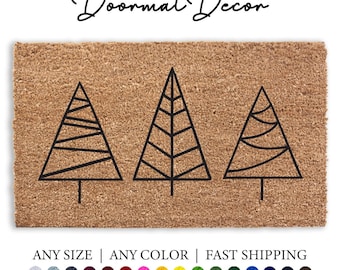 May include: A brown coir doormat with three black outline Christmas trees. The text "Doormat Decor" is at the top of the mat. The text "ANY SIZE | ANY COLOR | FAST SHIPPING" is at the bottom of the mat.
