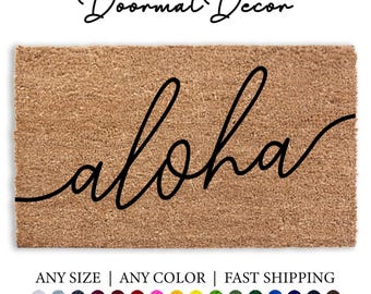May include: A brown coir doormat with the word "Aloha" written in black cursive script. The doormat is available in various sizes and colors.
