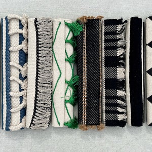 May include: Eight different patterned rugs with fringe, including leopard print, stripes, and geometric designs in black, white, and brown.