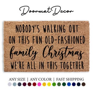 May include: A brown coir doormat with the text "NOBODY'S WALKING OUT ON THIS FUN OLD-FASHIONED family Christmas WE'RE ALL IN THIS TOGETHER" in black lettering.