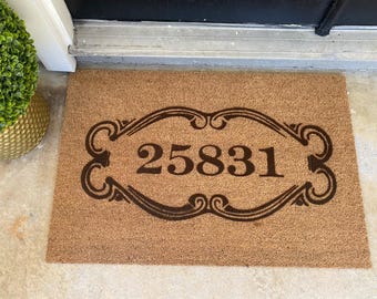 May include: A brown coir doormat with the number 25831 printed in a decorative black frame.