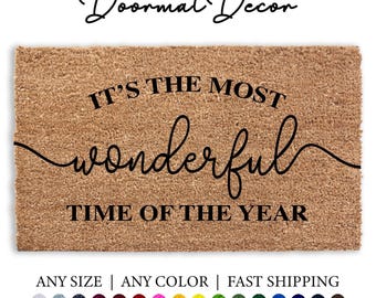 May include: A brown coir doormat with the text "IT'S THE MOST wonderful TIME OF THE YEAR" in black lettering.