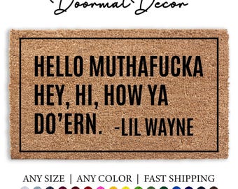 May include: A brown doormat with black text that reads "HELLO MUTHAFUCKA HEY, HI, HOW YA DO'ERN. -LIL WAYNE".
