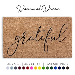 May include: A brown coir doormat with the word "grateful" written in black cursive script. The doormat is available in any size and color.