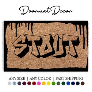 May include: A brown coir doormat with black dripping paint and the word "STOUT" in black graffiti font.