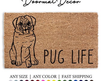 May include: A brown coir doormat with a black line drawing of a pug sitting and the text "PUG LIFE" in black.