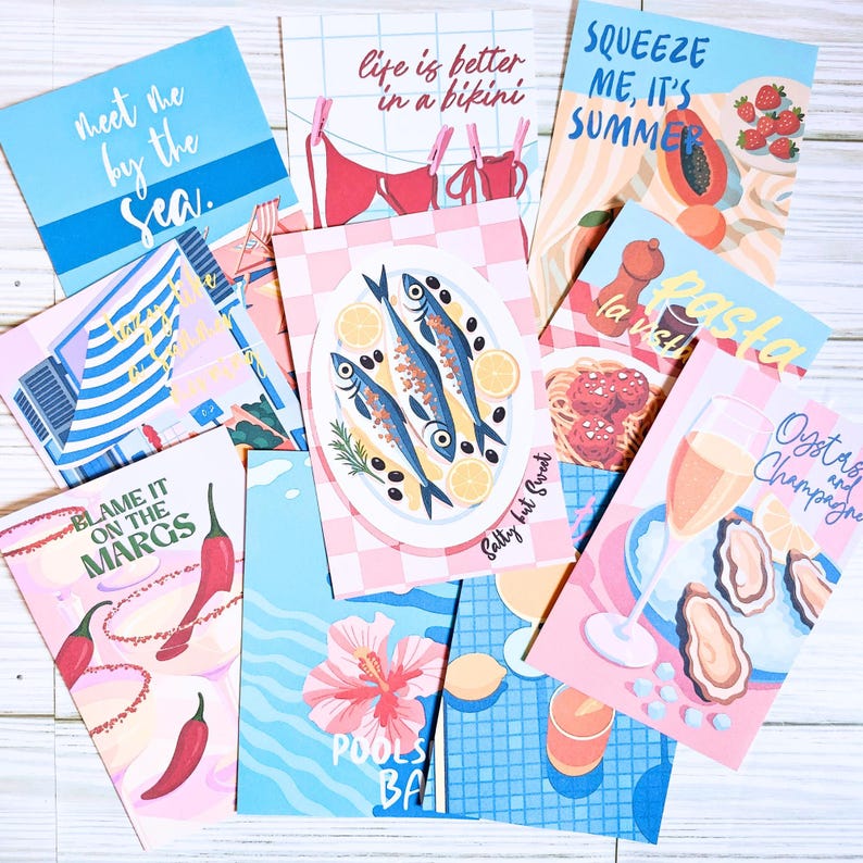 May include: A collection of rectangular greeting cards featuring colorful illustrations of summer themes, including seafood, cocktails, pasta, and beach scenes with text such as Meet me by the sea, Life is better in a bikini, Squeeze me, it's summer, Salty but sweet, Blame it on the margs, and Oysters and champagne.