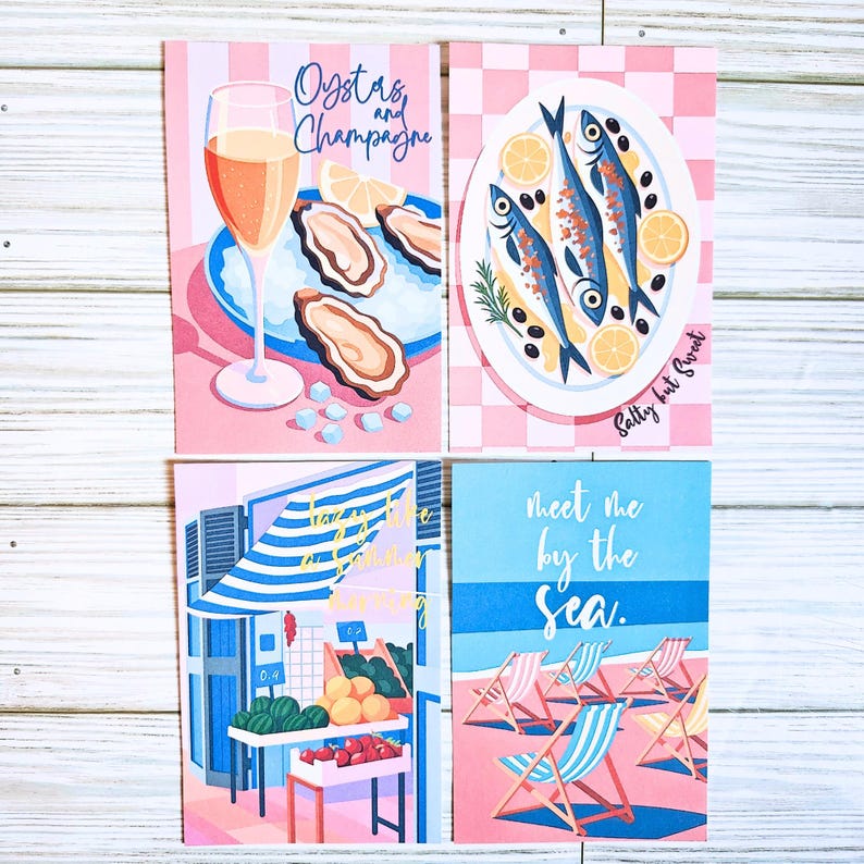 May include: Four rectangular art prints featuring illustrations. One shows oysters, champagne, and the text Oysters and Champagne. Another depicts fish on a plate with the text Salty but Sweet. A third shows a market scene with text, and the fourth shows beach chairs with the text meet me by the sea.
