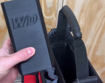 May include: A black tool bag with a red and black strap. The bag has a handle and a zippered compartment. The bag is labeled "Milwaukee" and has a "3x3 XL BIN!" label on the side.