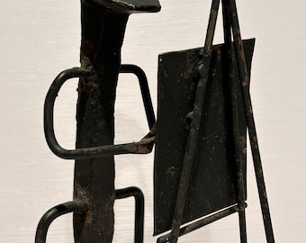 Escultura de arte popular antiguo de hierro forjado con forma de clavo de ferrocarril pintado.