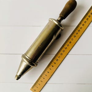 Vintage air pump style grease gun Perolin shown with ruler for scale, antique lubrication tool displayed to demonstrate overall size
