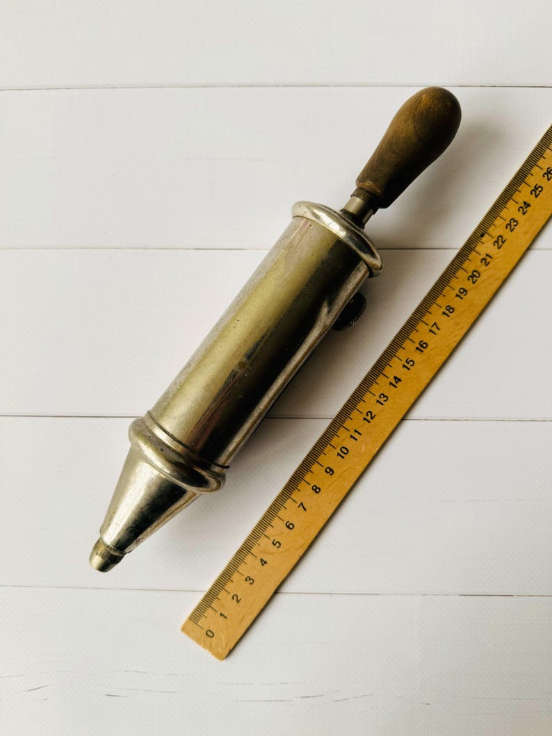 Vintage air pump style grease gun Perolin shown with ruler for scale, antique lubrication tool displayed to demonstrate overall size