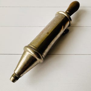 Antique air pump style lubrication tool by Perolin, close view of the metal body with aged patina, French vintage mechanic tool