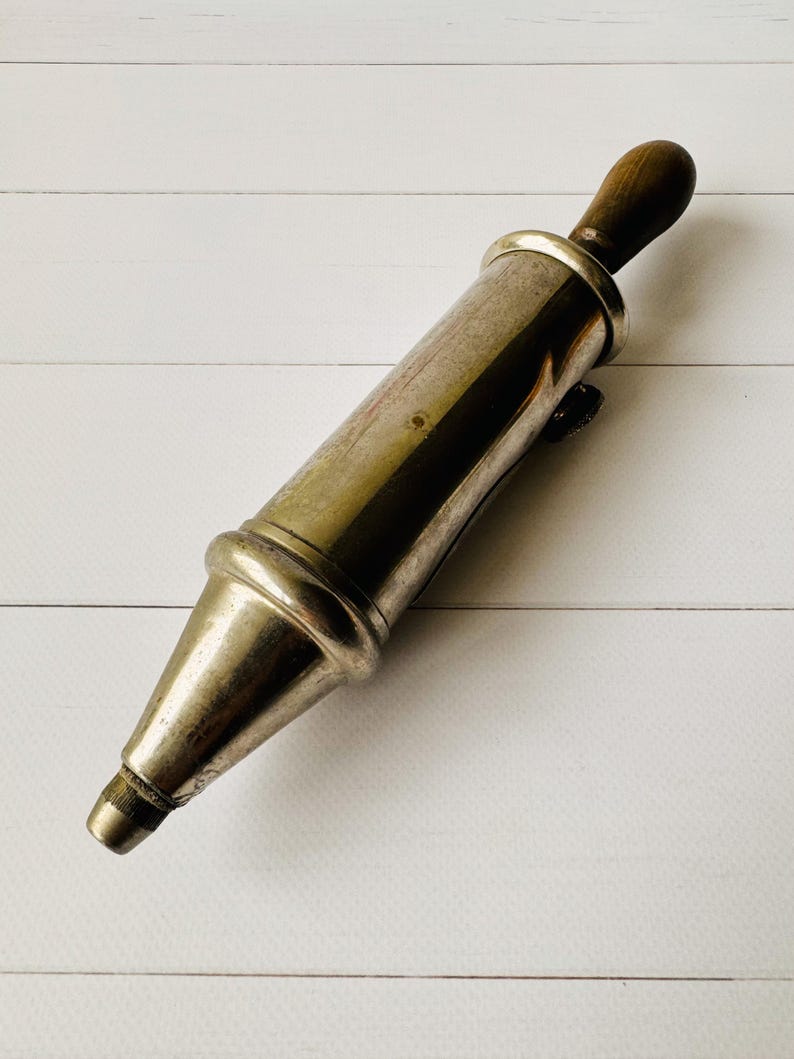 Antique air pump style lubrication tool by Perolin, close view of the metal body with aged patina, French vintage mechanic tool