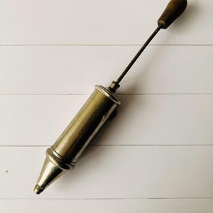 Antique Perolin lubrication tool fully extended, vintage air pump design with long metal rod and wooden handle, collectible antique tool