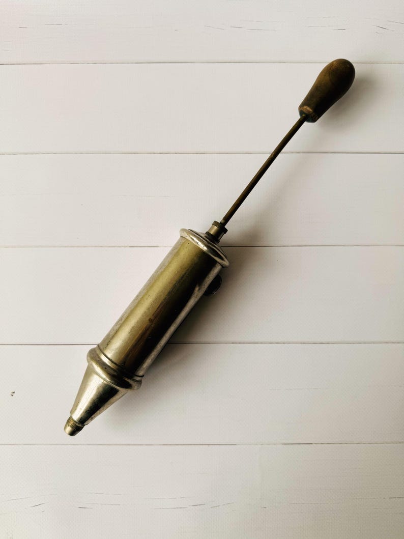 Antique Perolin lubrication tool fully extended, vintage air pump design with long metal rod and wooden handle, collectible antique tool