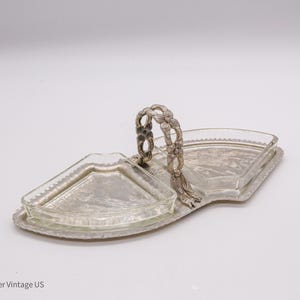 May include: A silver serving tray with two glass dishes. The tray has a decorative handle and the dishes are shaped like half circles.