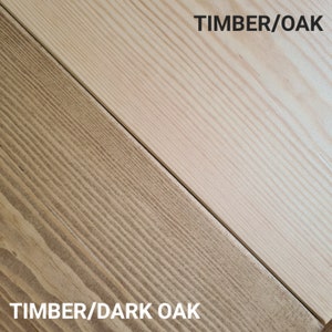 May include: A diagonal split image showcasing two wood samples. One is light-colored, labeled "TIMBER/OAK," and the other is darker, labeled "TIMBER/DARK OAK." The wood grain is visible, highlighting the natural texture and color variations.