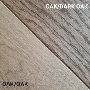 May include: Two samples of wood flooring, divided diagonally. One section is light oak, the other is dark oak. The text "OAK/DARK OAK" and "OAK/OAK" are printed on the image.