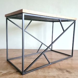 May include: A black metal side table with a geometric design and a wooden top.