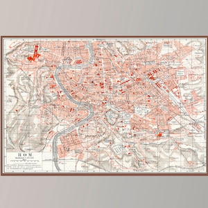 May include: A vintage map of Rome, Italy, printed in black and white with red highlights. The map is framed in a brown frame and is hanging on a light gray wall.