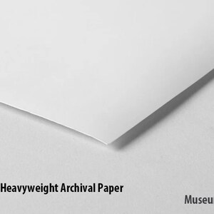 May include: Close-up of a white, 250gsm heavyweight archival paper. The paper is smooth and has a slight sheen. The text "Museum-quality" is printed below the paper.