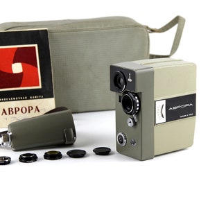 May include: A vintage 8mm film camera with a gray body and black lens. The camera is labeled "ABPOPA" and comes with a gray carrying case, a strap, and four lens filters.
