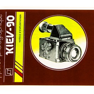May include: A brown and yellow instruction manual for a Kiev-90 camera. The cover features a black and silver camera with a yellow circle around it. The text "NOTICE D'EXPLOITATION" is visible on the right side of the cover.