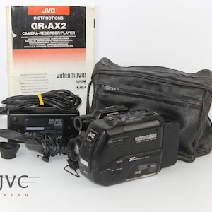 Film Cinema Filming  apparatus Video Camera JVC Compact Video Movie GR - AX2EG  8 mm 6 X ZOOM Lens 1 : 1.6 f = 1.4  f = 7 - 42 mm Japan