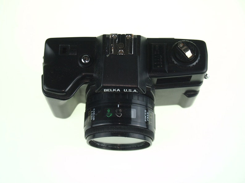 May include: A black Belka U.S.A. 35mm film camera with a lens that says "Canon Zoom Lens 35-70mm 1:3.5-5.6".