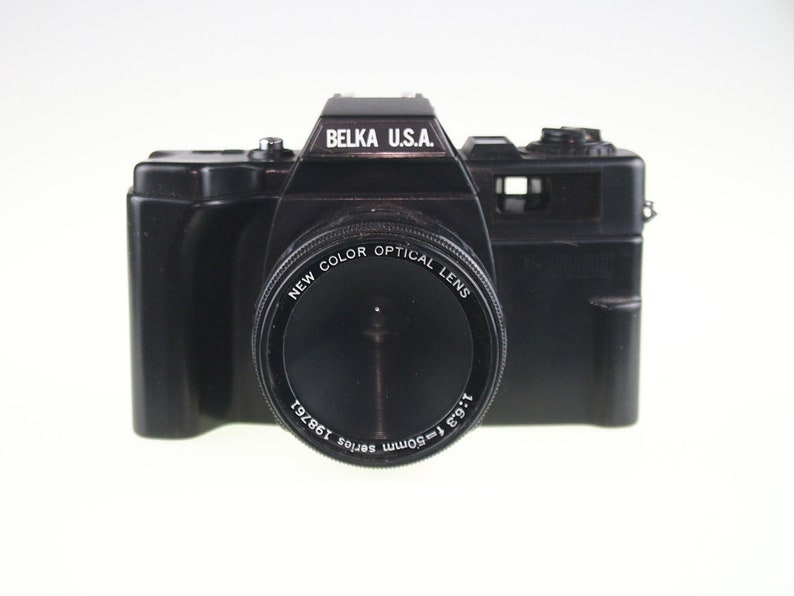 May include: A black Belka U.S.A. 35mm film camera with a New Color Optical Lens. The lens has a 1:9.3 50mm Serios 138721 inscription.