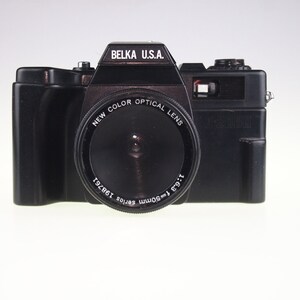 May include: A black Belka U.S.A. 1-2000 camera with a New Color Optical Lens. The lens is labeled 1:6.3 f-50mm series 198761.