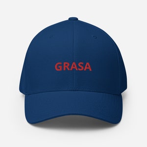 以下が含まれることがあります： 前面に赤い糸で「GRASA」と刺繍されたネイビーブルーのベースボールキャップです。
