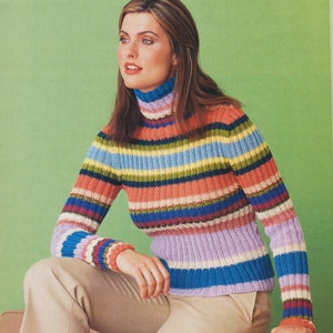 Könnte beinhalten: Ein gestreifter Rollkragenpullover mit verschiedenen Farben, darunter Rosa, Blau, Grün und Gelb. Der Pullover ist aus weichem, gestricktem Stoff gefertigt und hat eine lockere Passform.