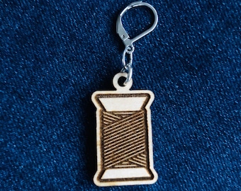 Marcador de punto de madera con cierre de palanca con canilla de hilo.