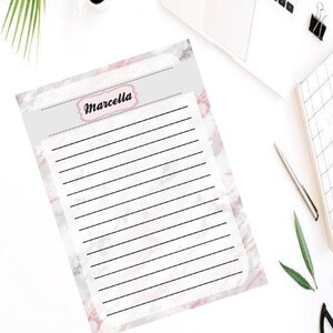 Op de afbeelding: Een bedrukbaar, gestreept vel papier met een roze en witte marmerachtergrond. Het papier heeft bovenaan een titel die "Marcella" in zwarte cursieve letters zegt.