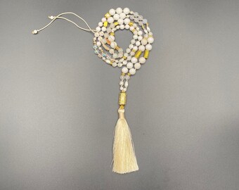 hand-knotted white/gold pearl necklace with stylized prayer wheel and silk tassel