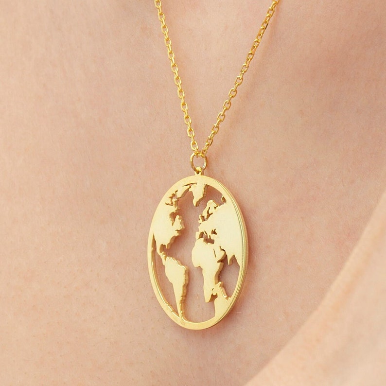 May include: A gold necklace with a pendant shaped like the world. The pendant is cut out to show the continents.
