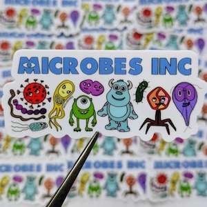 Peut inclure: Un autocollant blanc avec le texte bleu "MICROBES INC", représentant des illustrations de microbes de dessins animés en rouge, jaune, vert, violet et bleu. L'autocollant est tenu par une pince à épiler.