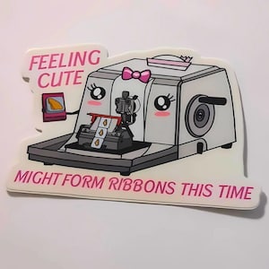 May include: A white sticker with a cartoon illustration of a machine with a pink bow and the text "Feeling Cute" and "Might Form Ribbons This Time".