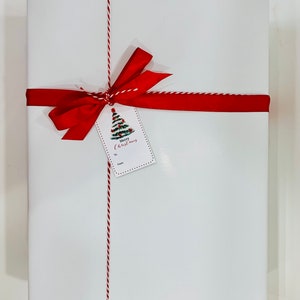 May include: White gift box with a red ribbon and a gift tag that says "Merry Christmas".
