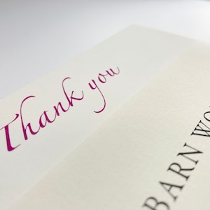 May include: A white card with the words "Thank you" written in purple cursive script. The bottom of the card has the words "Barn Workshop" printed in black.