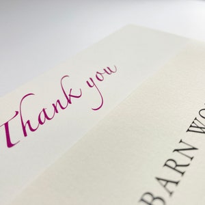 May include: A white card with the words "Thank you" written in purple cursive script. The bottom of the card has the words "Barn Workshop" printed in black.