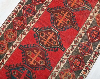 Könnte beinhalten: Ein roter, brauner und cremefarbener Teppich mit geometrischem Muster. Der Teppich hat ein traditionelles Design mit komplizierten Details.